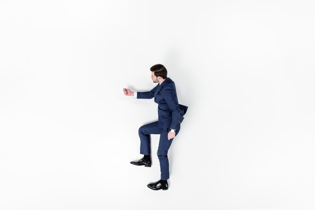 top view of young businessman pretending to walk upstairs isolated on white - Photo, Image