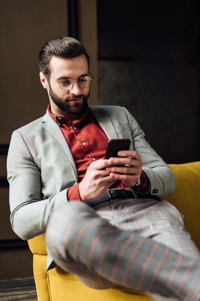 hombre elegante guapo en gafas usando teléfono inteligente
  - Foto, imagen