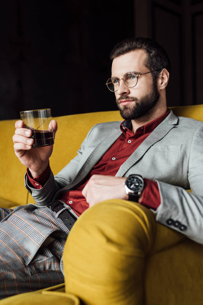 pensive handsome man holding glass of whiskey   - Photo, Image