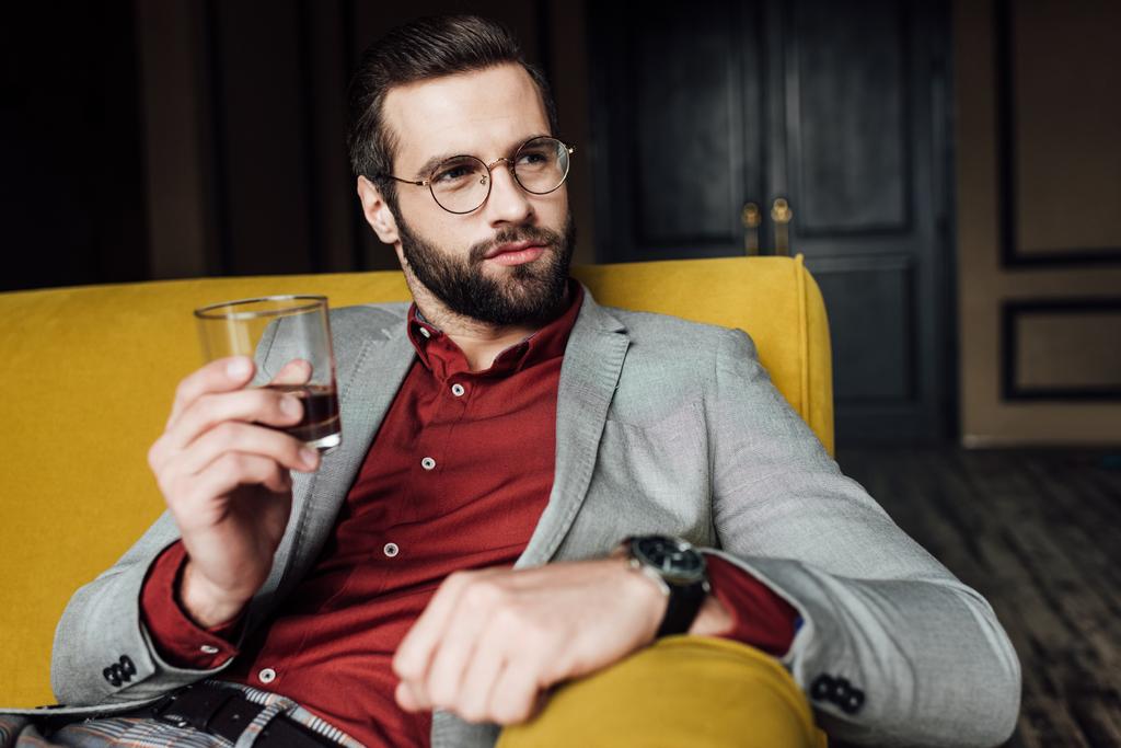 stylish bearded man holding glass of whiskey   - Photo, Image