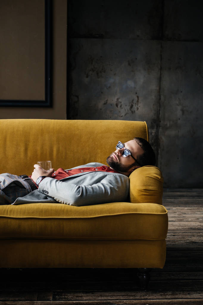 humalassa mies aurinkolasit lasi viskiä nukkuu keltainen sohva
 - Valokuva, kuva
