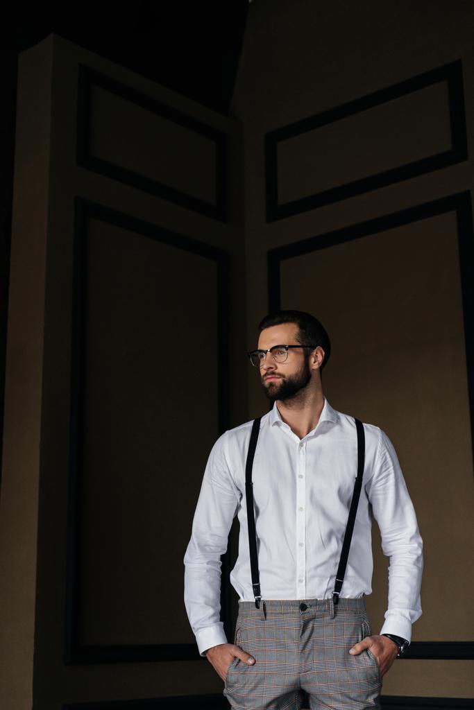όμορφος κομψός άνθρωπος που θέτουν σε λευκό πουκάμισο και ζαρτιέρες - Φωτογραφία, εικόνα