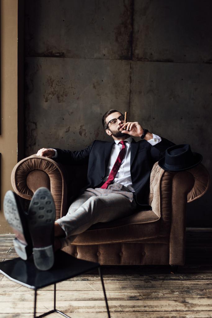 fashionable businessman sitting in armchair and smoking cigar - Photo, Image