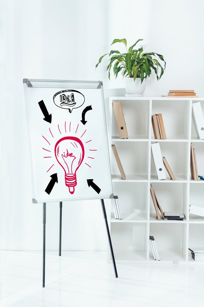 whiteboard with idea symbols and wooden shelves with folders in office - Photo, Image