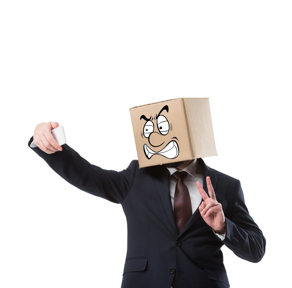 homme d'affaires avec boîte en carton sur la tête prendre selfie sur smartphone isolé sur blanc
   - Photo, image