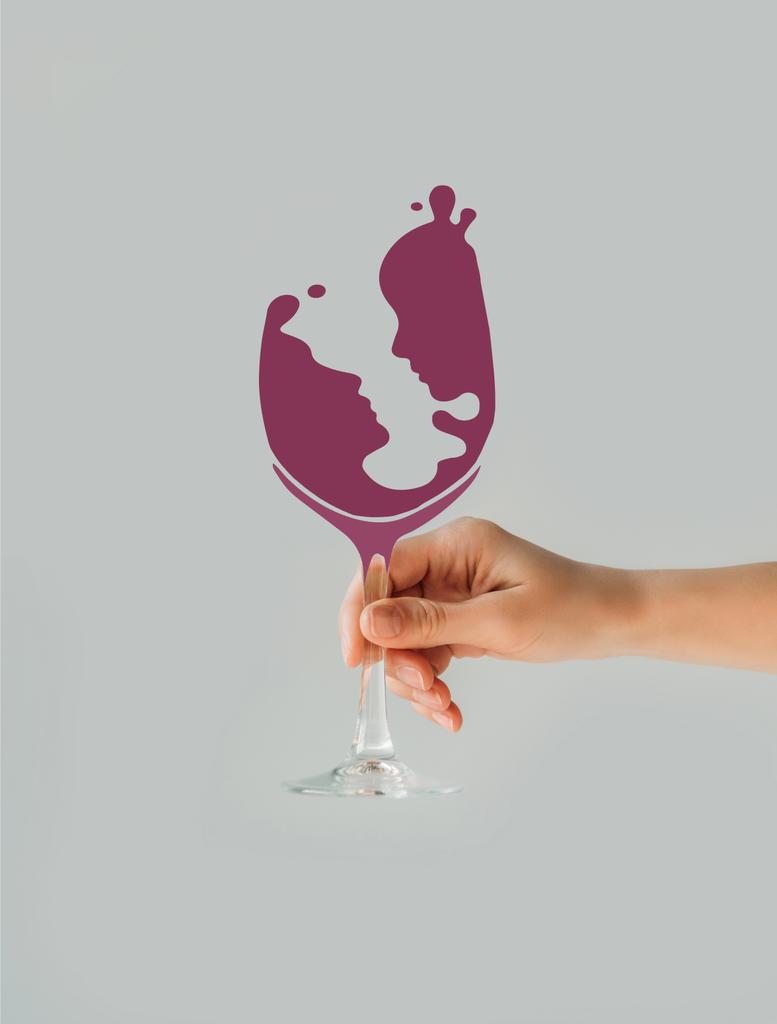 Oříznout obrázek ženy držící sklenice na víno s pár silueta izolované na šedé - Fotografie, Obrázek