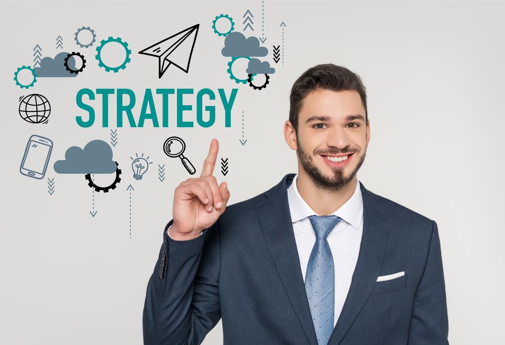 smiling young businessman pointing up with finger and looking at camera, strategy concept  - Photo, Image