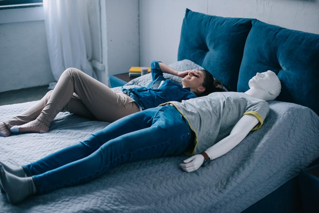 молодая женщина лежит в постели с манекеном, идеальная концепция отношений сон
 - Фото, изображение