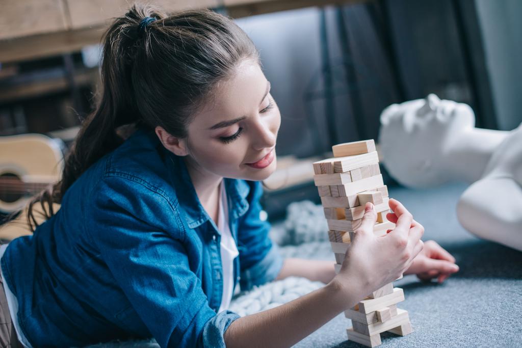 foco seletivo da mulher jogando blocos de jogo de madeira com boneca leigo perto de casa, conceito de sonho de relacionamento perfeito
 - Foto, Imagem
