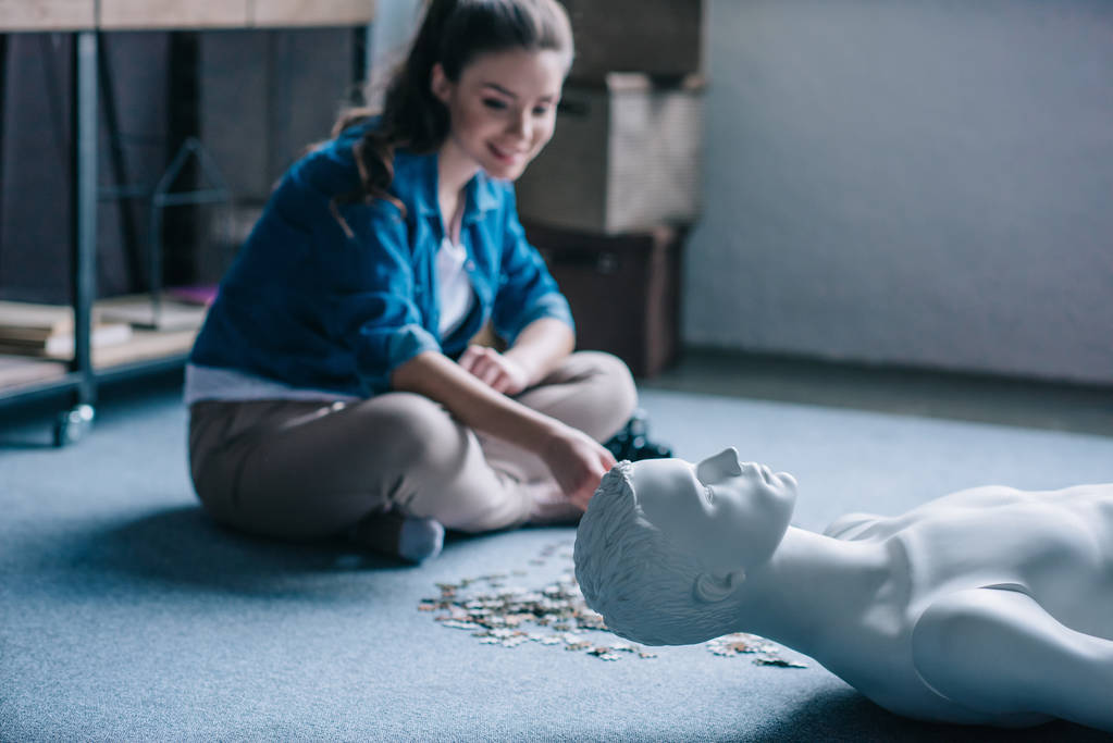 woman playing with puzzles with manikin near by, perfect relationship dream concept - Photo, Image