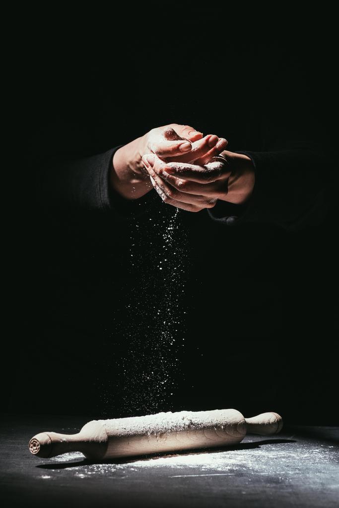 tiro recortado de chef con las manos cubiertas de harina y rodillo en la mesa
 - Foto, imagen