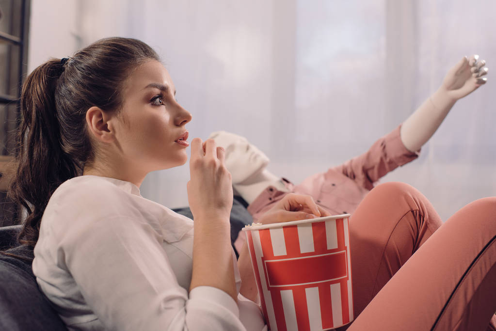 γυναίκα τρώει ποπ κορν βλέποντας ταινία μαζί με το ανδρείκελο στο σπίτι, τέλεια σχέση όνειρο έννοια - Φωτογραφία, εικόνα