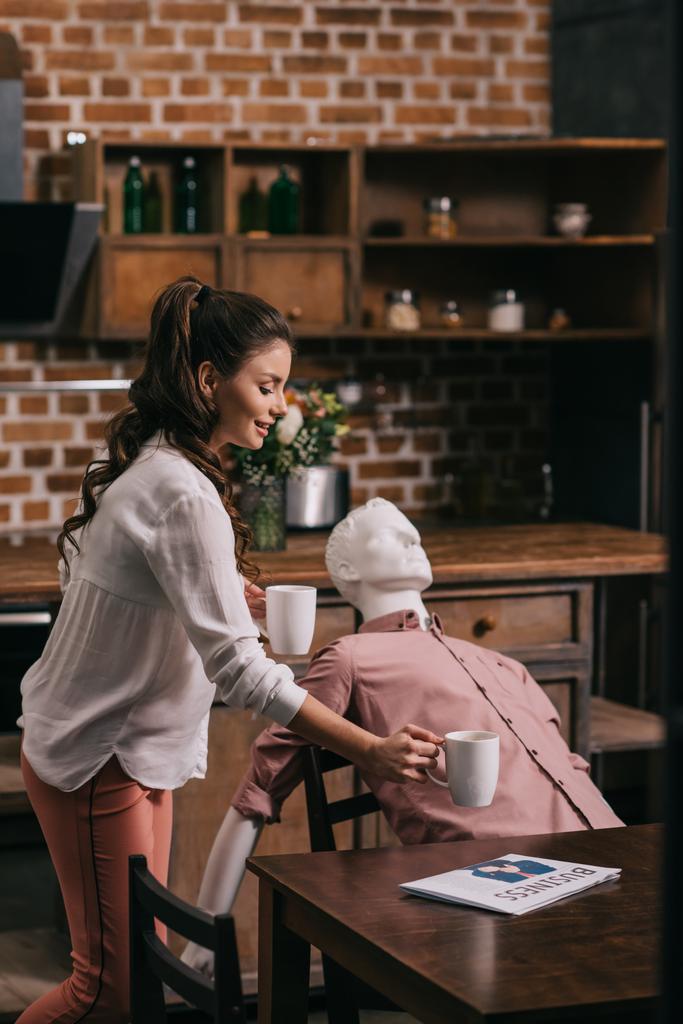 woman serving coffee to manikin at home, perfect relationship dream concept - Photo, Image