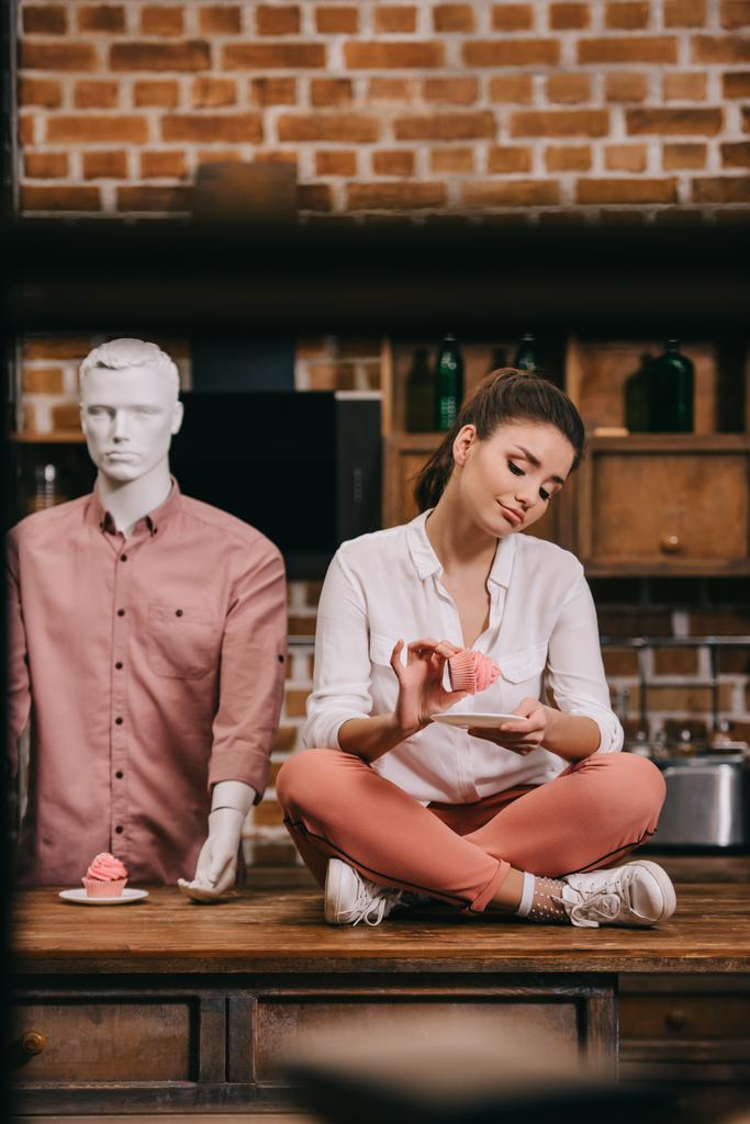 cupcake manken arkasında, yalnızlık kavramı ile masaya oturan kadınla - Fotoğraf, Görsel