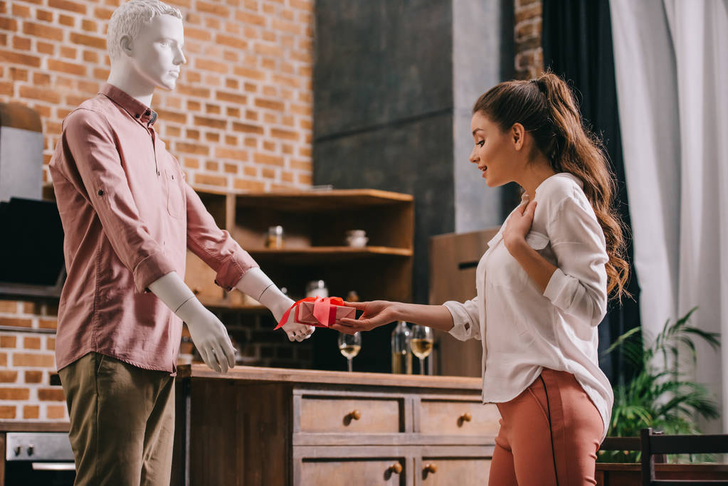 woman pretending to except gift from mannikin, loneliness and perfect man dream concept - Photo, Image