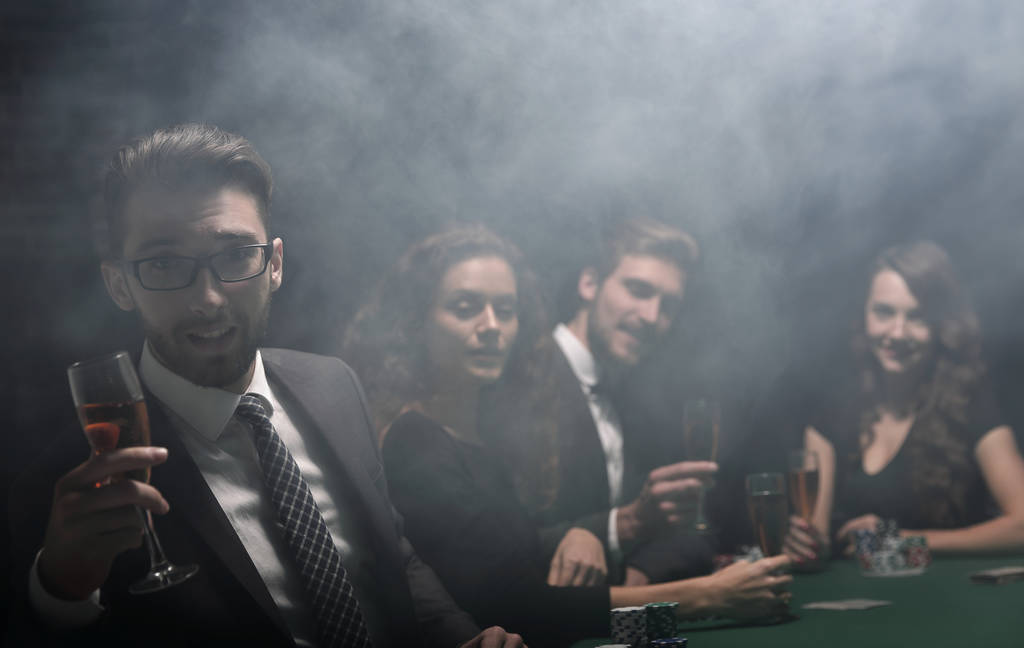 jugadores de póquer con una copa de vino, sentado en una mesa
 - Foto, imagen