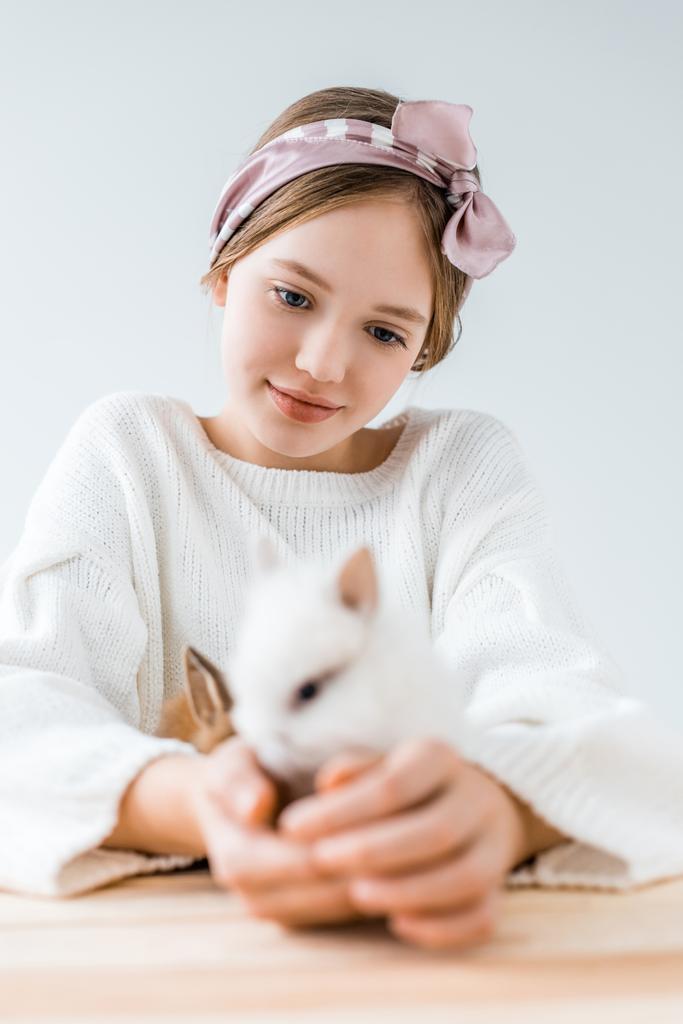 foco seletivo de menina sorridente segurando coelhos peludos bonitos no branco
  - Foto, Imagem