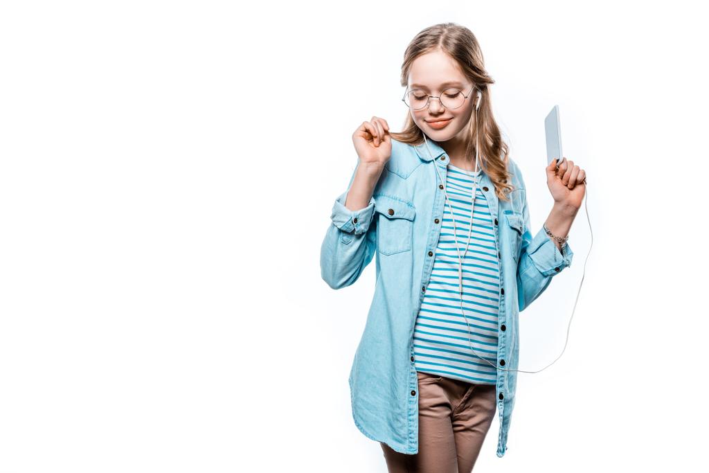 krásná usměvavá dívka v sluchátka poslouchat hudbu s smartphone izolované na bílém - Fotografie, Obrázek