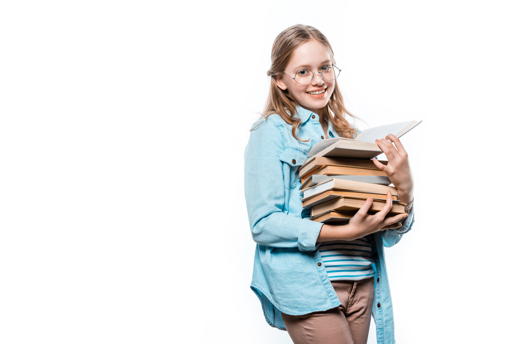 красивая девочка-подросток в очках держит стопку книг и улыбается в камеру изолированной на белом
 - Фото, изображение