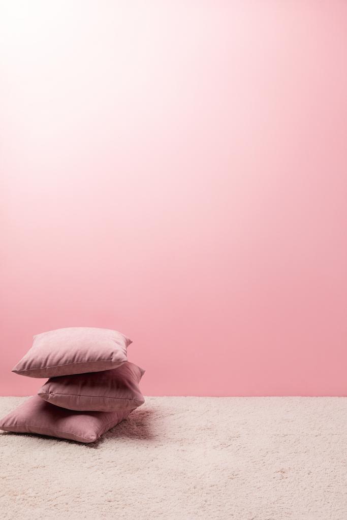 cuscini su tappeto davanti alla parete rosa
 - Foto, immagini