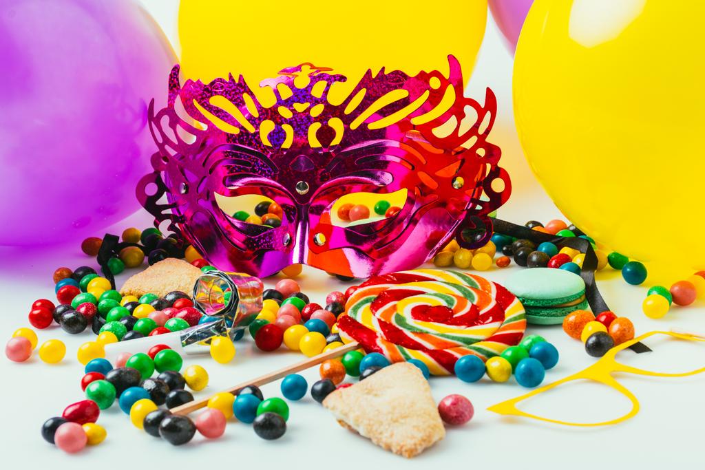 Balonlar, maskeli balo maskeleri ve şekerler, purim tatil kavramı görünümünü kapat - Fotoğraf, Görsel