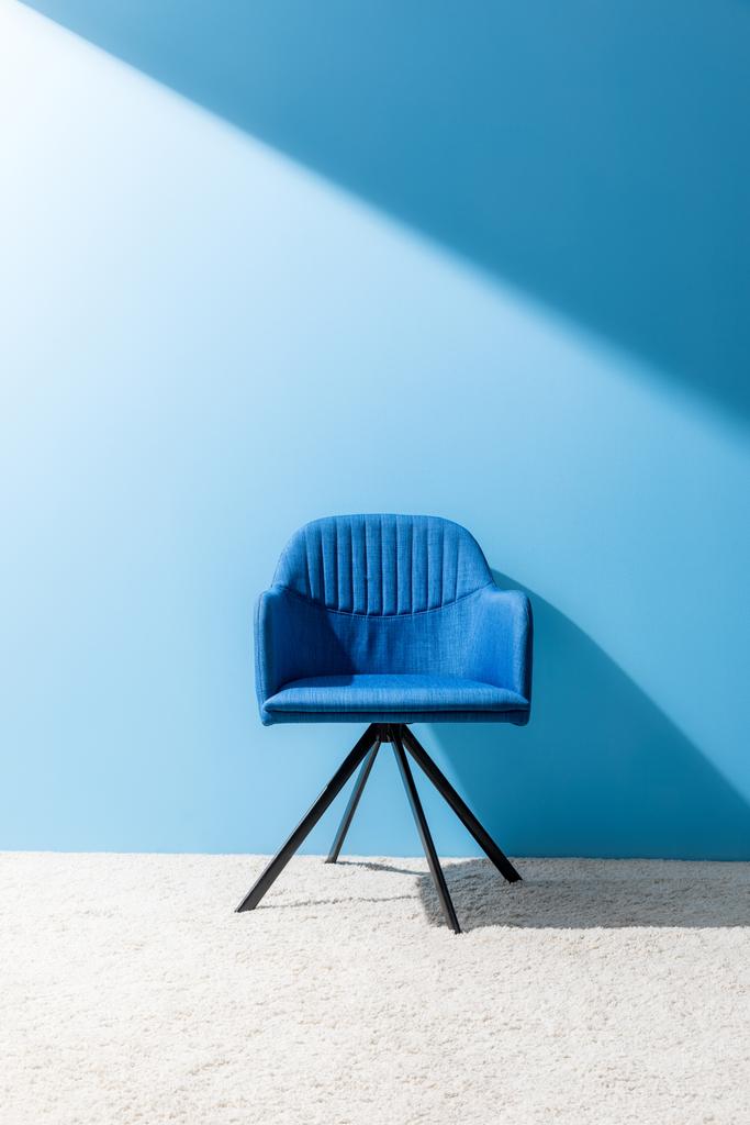 удобный синий стул перед синей стеной
 - Фото, изображение