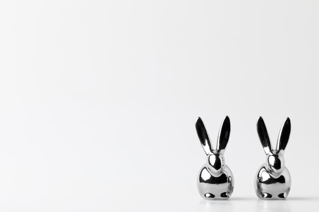 duas estatuetas de coelhos de Páscoa de prata em branco
 - Foto, Imagem