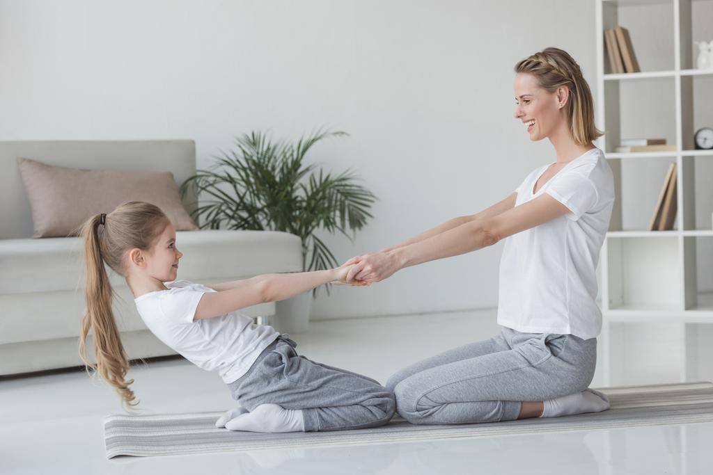 matka i Córka, stojąc na kolana i praktykowania jogi acro - Zdjęcie, obraz