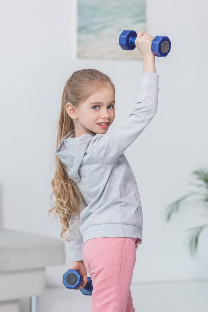 beautiful little child working out with dumbbells - Photo, Image