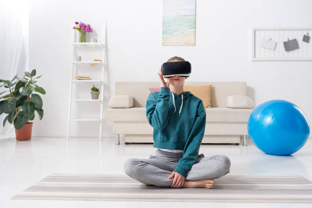 lány ült a lótusz helyzet a virtuális-valóság sisak otthon - Fotó, kép