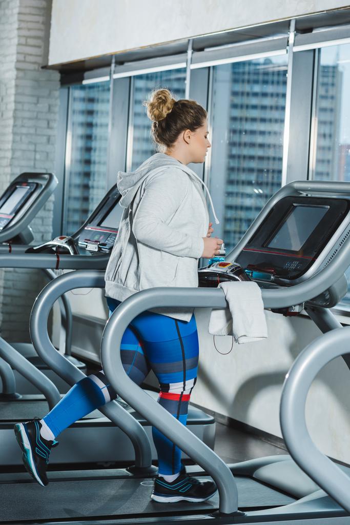kilolu kadın spor salonunda treadmill eğitim - Fotoğraf, Görsel