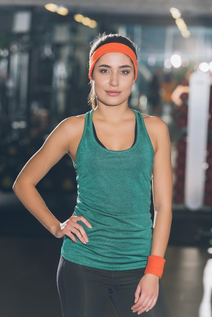 femme sportive debout à la salle de gym avec la main à la taille et en regardant la caméra
 - Photo, image