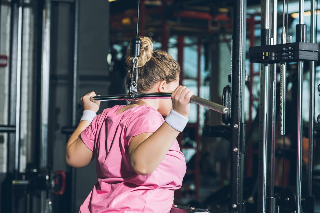 ylipainoinen nainen treenaa harjoituslaitteita
     - Valokuva, kuva