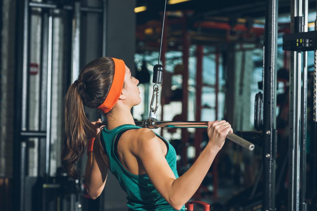 mujer deportiva entrenando su pecho en aparato de entrenamiento
   - Foto, imagen