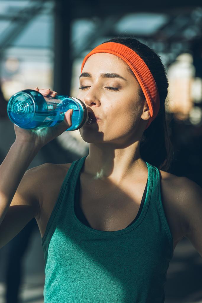 σπορ γυναίκα πόσιμου νερού στο γυμναστήριο με κλειστά τα μάτια - Φωτογραφία, εικόνα