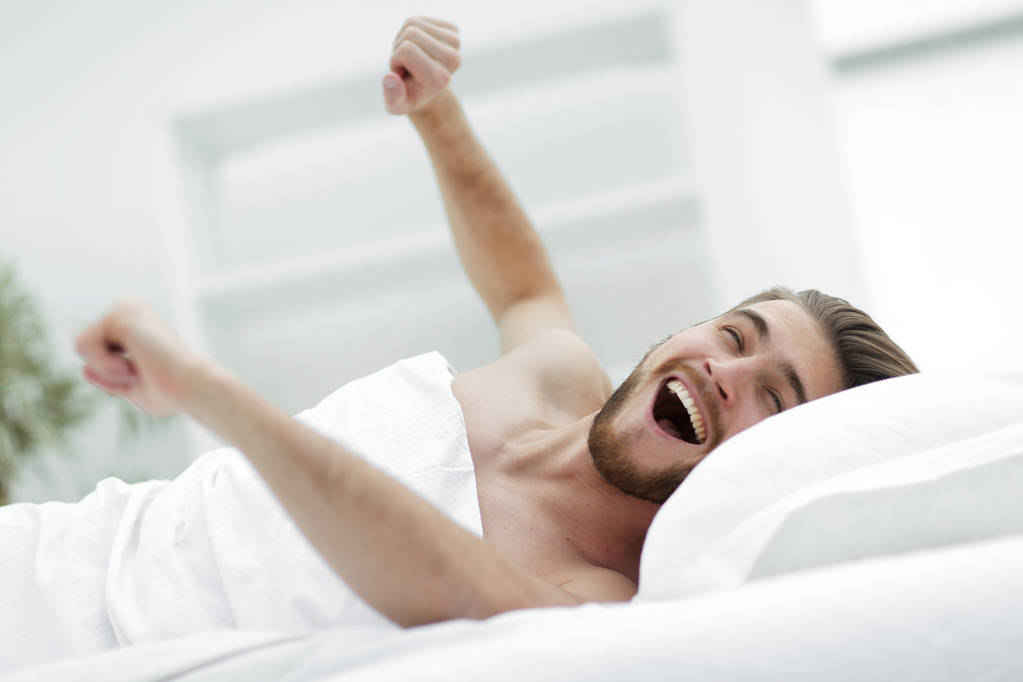 szczęśliwy człowiek budzi się w wygodnym pokoju - Zdjęcie, obraz