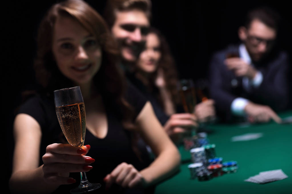 mujer de moda con copas de vino, sentada en una mesa en un casino
 - Foto, Imagen