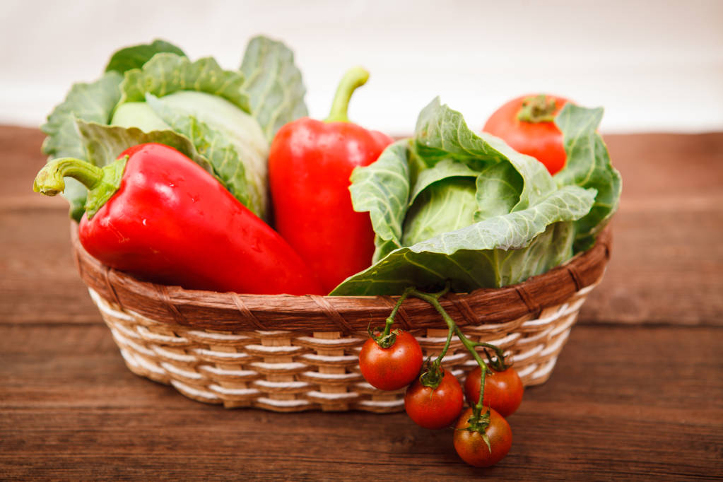 Mand met verse groenten op een houten tafel. Tomaten, Bulgar - Foto, afbeelding