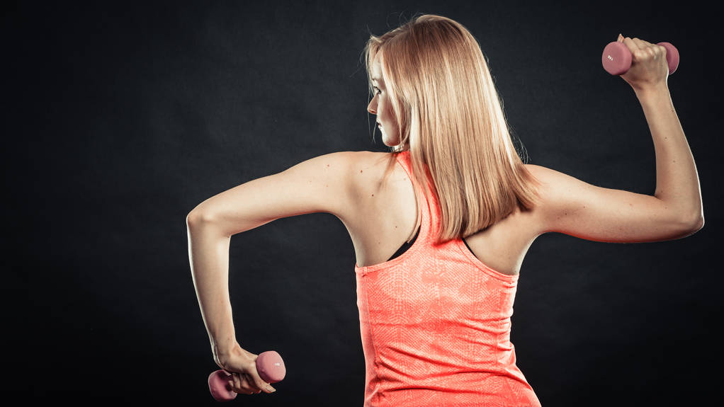Fitness urheilullinen tyttö nosto painot takaisin näkymä
 - Valokuva, kuva