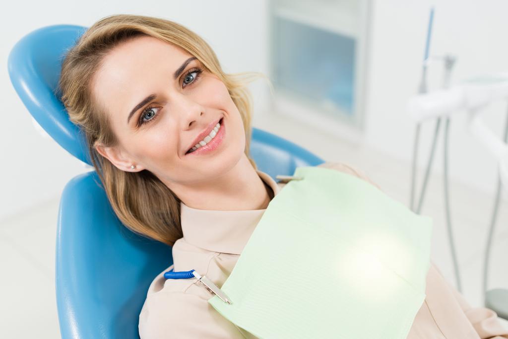 Uśmiechnięta kobieta w check-up w nowoczesny gabinet stomatologiczny - Zdjęcie, obraz