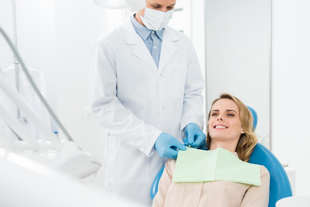 Doktor řešení ženských pacientů ubrousek v moderní zubní kliniky - Fotografie, Obrázek