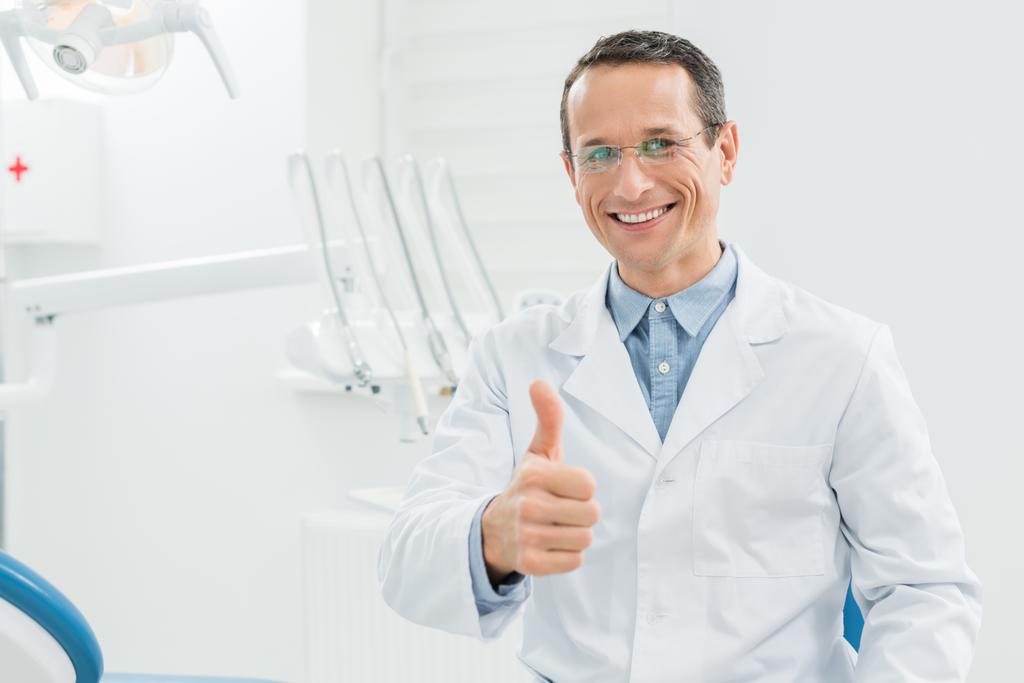 Tandarts tonen duim omhoog in moderne tandheelkundige kliniek - Foto, afbeelding