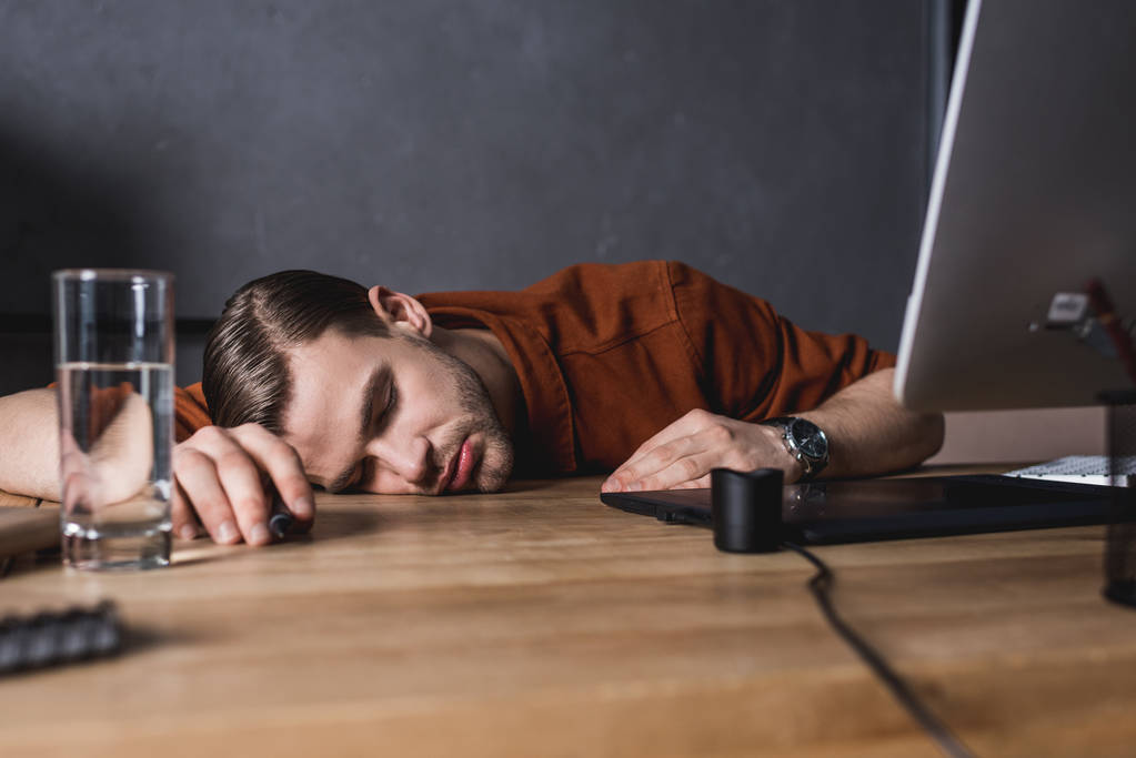 exceso de trabajo joven diseñador durmiendo en el lugar de trabajo
 - Foto, Imagen