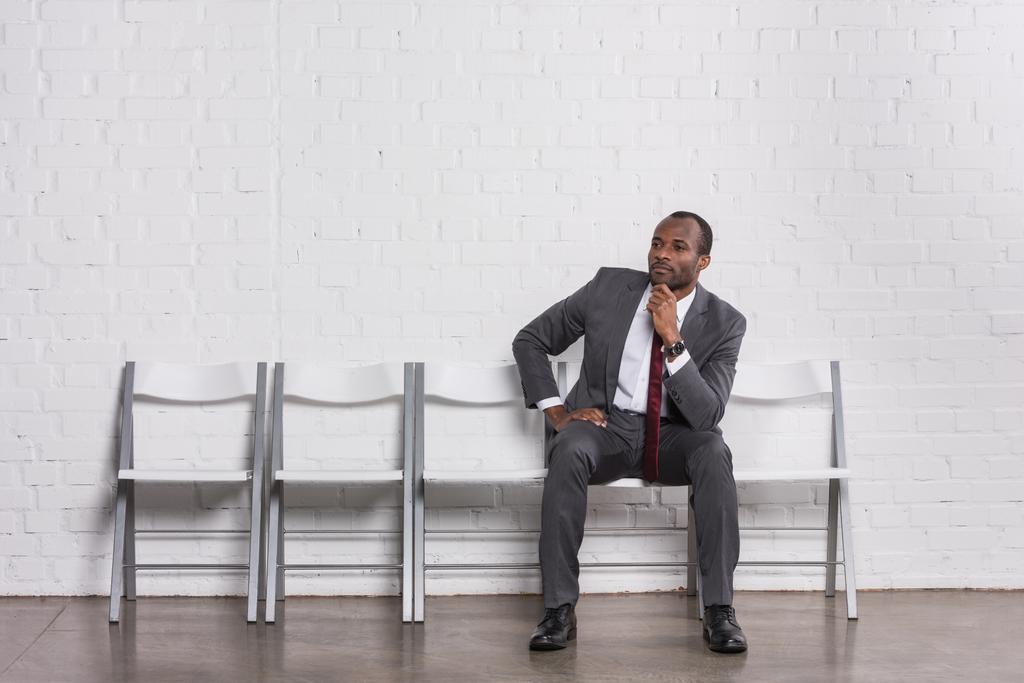 συλλογισμένος Αφρικανικός Αμερικανός επιχειρηματίας αναμονή για συνέντευξη για δουλειά - Φωτογραφία, εικόνα