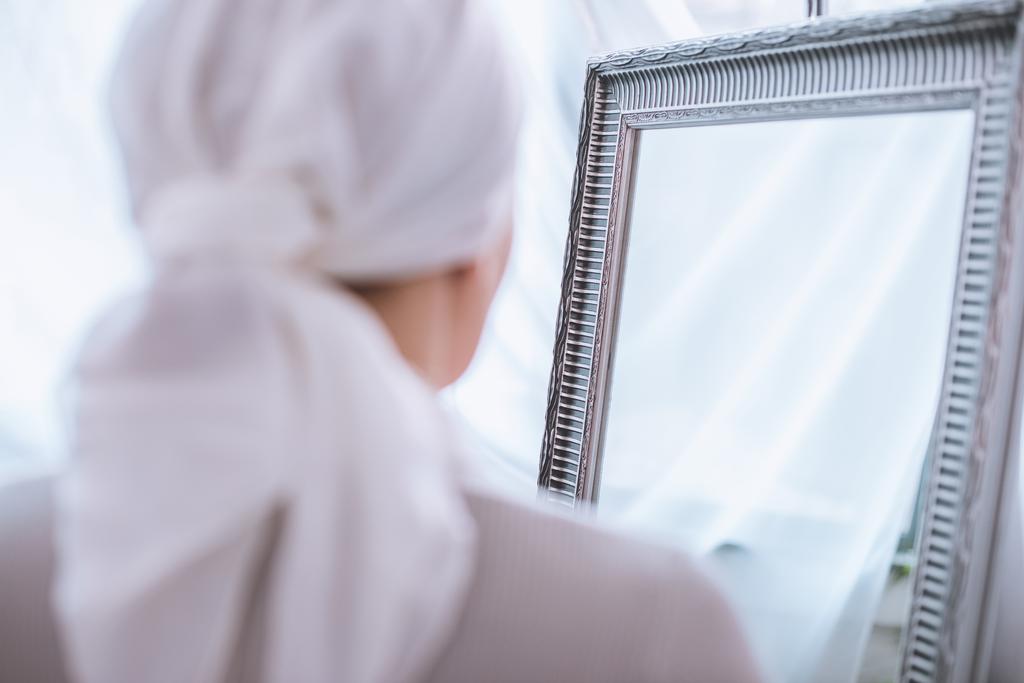 vue arrière de la femme malade dans le mouchoir debout près du miroir, concept de cancer
  - Photo, image