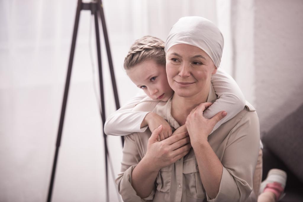 мила маленька дитина обіймає хвору бабусю в хустці
 - Фото, зображення