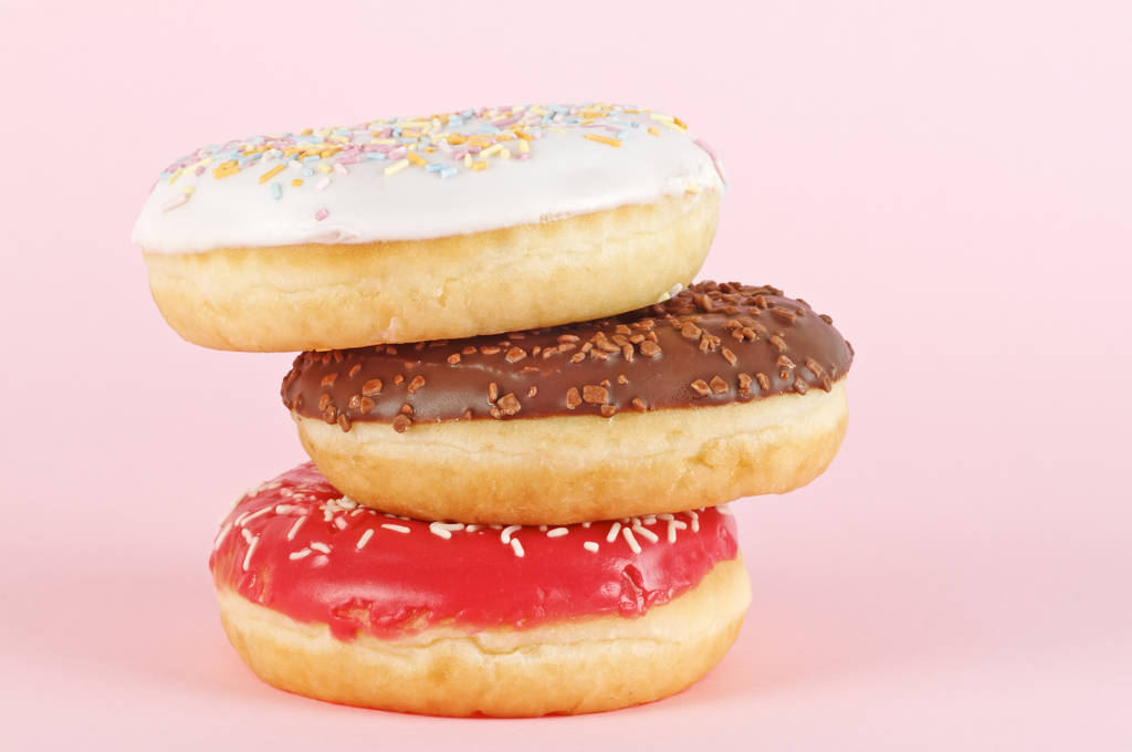 Três donuts com cobertura no fundo rosa. Doce donuts
.  - Foto, Imagem