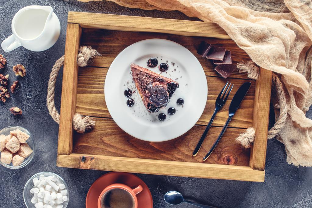 木製トレイのプレートにチョコレート ケーキお預けのトップ ビュー - 写真・画像