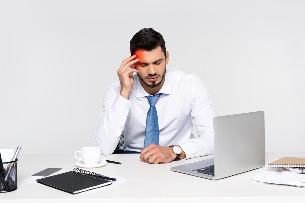 giovane uomo d'affari oberato di lavoro che soffre di mal di testa mentre è seduto sul posto di lavoro
  - Foto, immagini