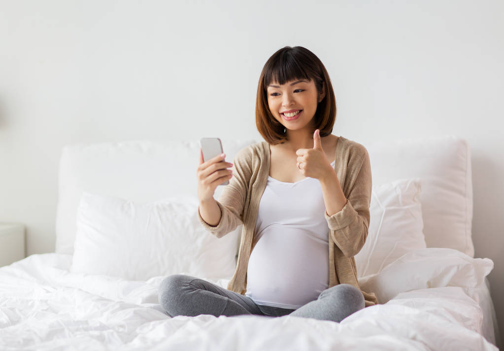 mujer embarazada tomando selfie por teléfono inteligente en casa
 - Foto, Imagen